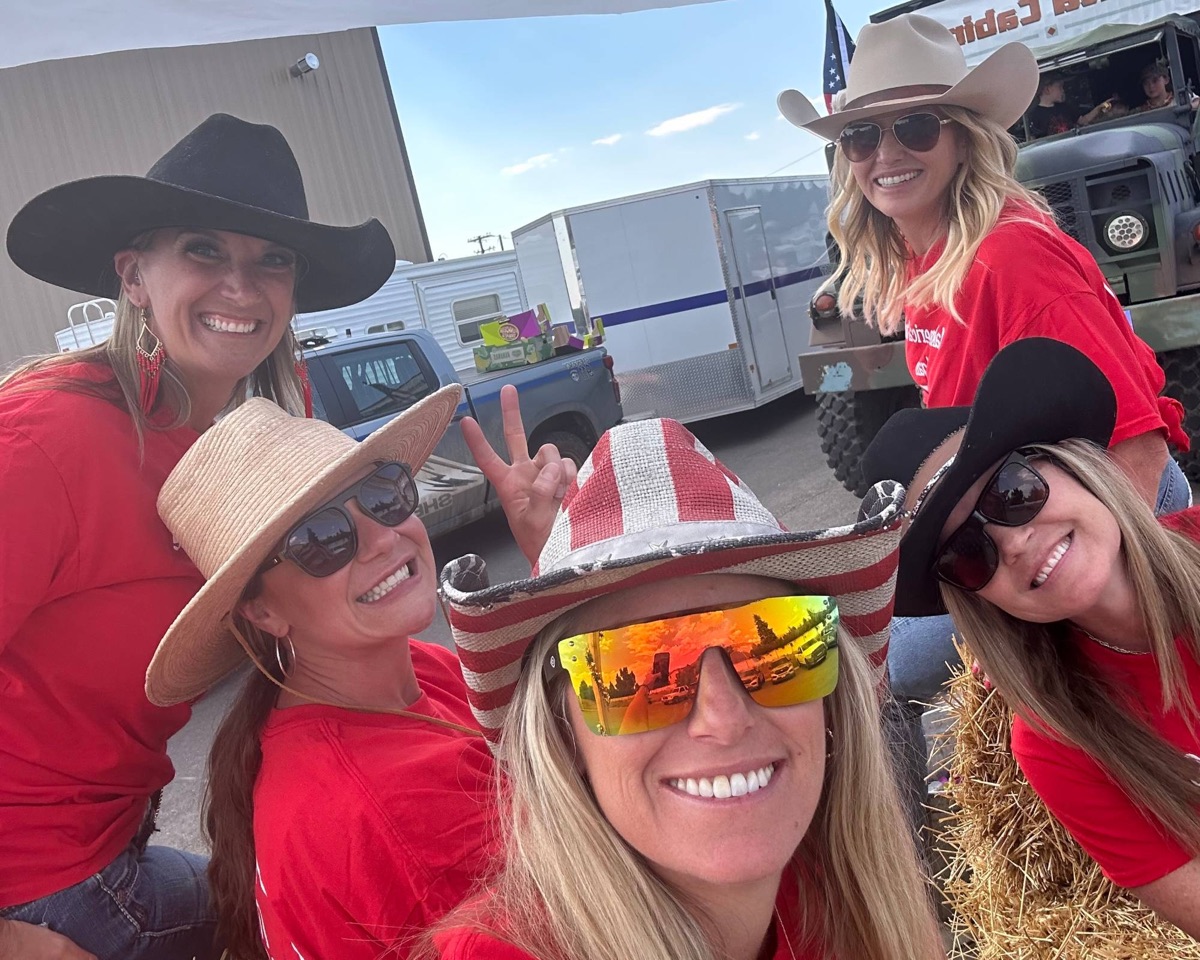 Miller Orthodontics team members in matching red shirts and cowboy hats on a hay-bale parade float