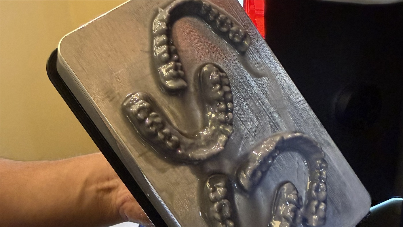 3D-printed dental models on a printer build plate, made in our office for uLab aligners
